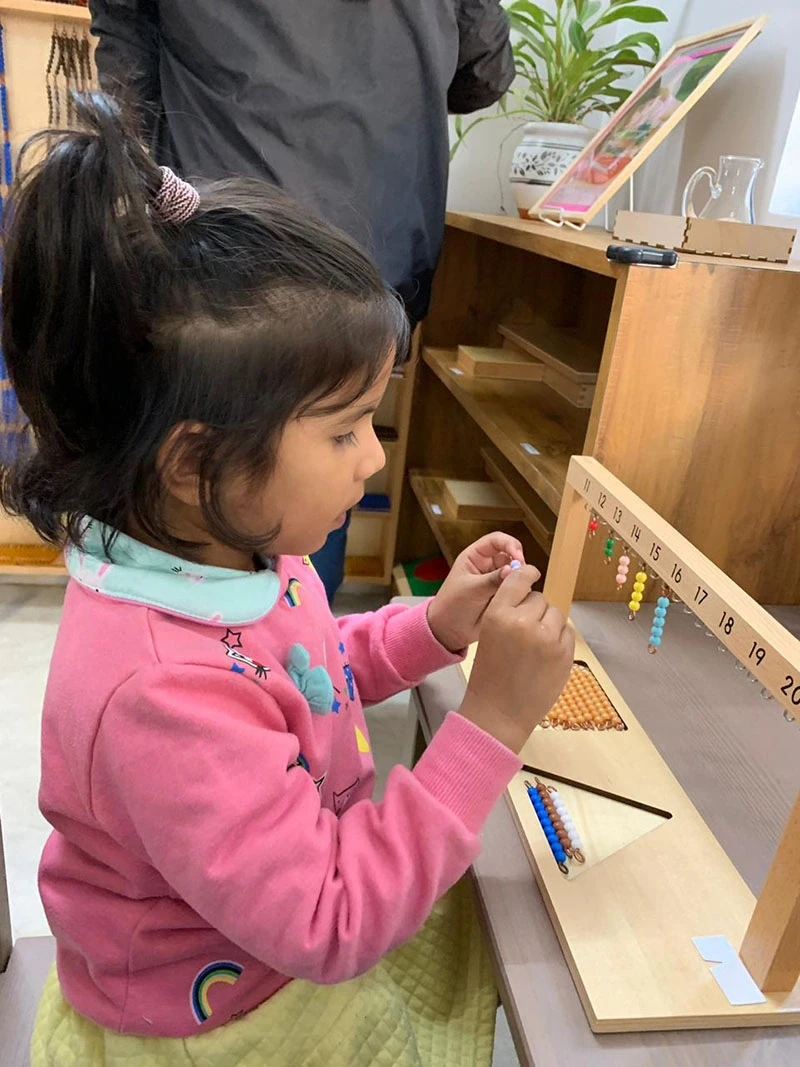 Toddler operating latch hooks and small locks on an interactive panel