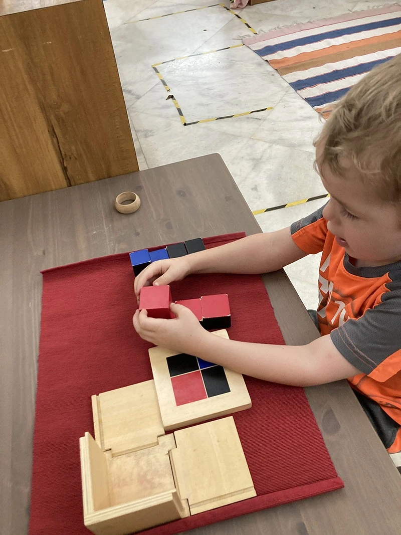 Child scrubbing a wooden table with soapy water